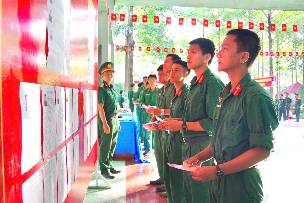 Các chiến sĩ Trung đoàn 271 tìm hiểu thông tin các ứng cử viên trước giờ bỏ phiếu. Ảnh: HN.
