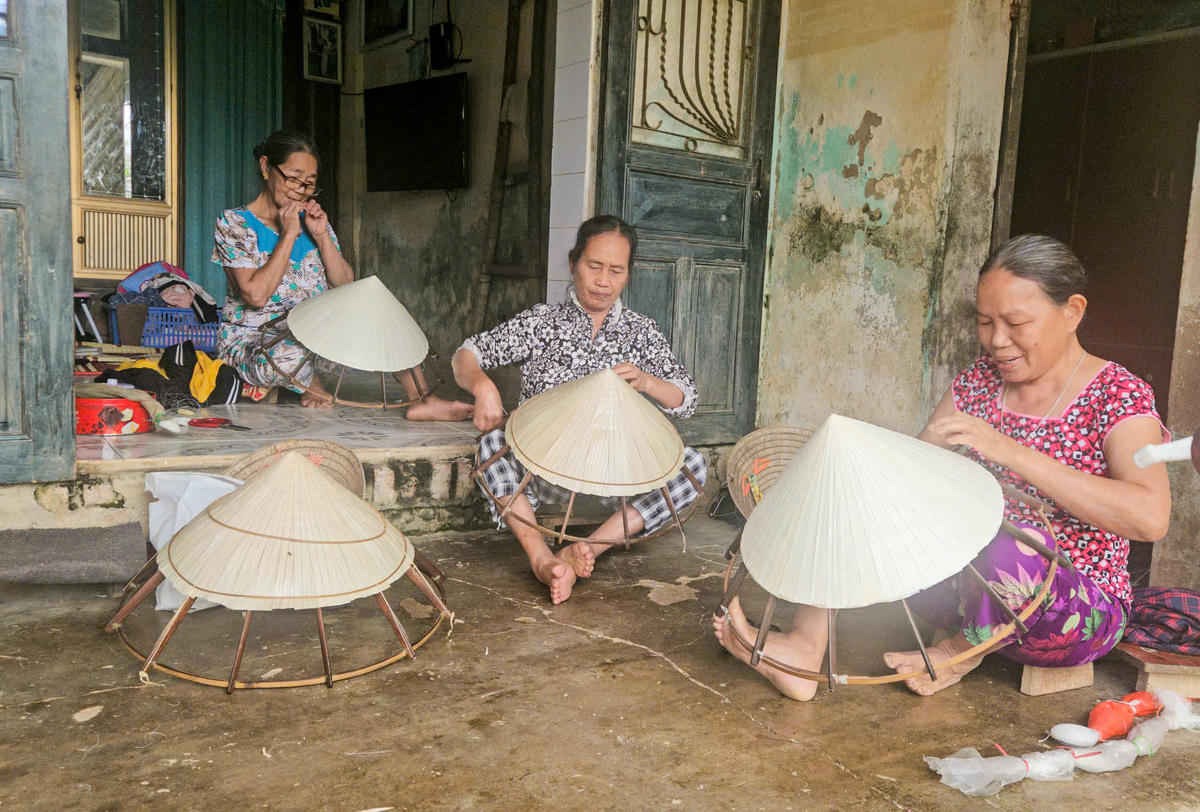 Nhiều hộ gia đình trong thôn đều sắp xếp công việc để đi bỏ phiếu sớm rồi trở về tiếp tục chằm nón. Ảnh: Cẩm Kỳ&nbsp;