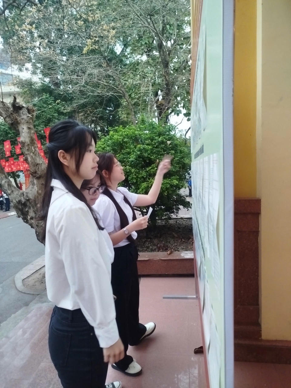 Cử tri trẻ tìm hiểu thông tin về ứng cử viên tại khu vực bỏ phiếu số 19, Đại học Kinh tế Quốc dân. Ảnh: Lê Thắm.