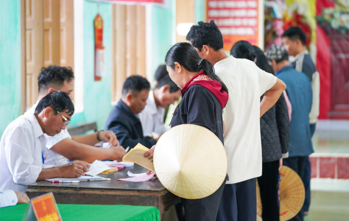 Các cử tri&nbsp;ký tên vào danh sách, nhận phiếu&nbsp;và bỏ phiếu vào hòm. Ảnh: Cẩm Kỳ