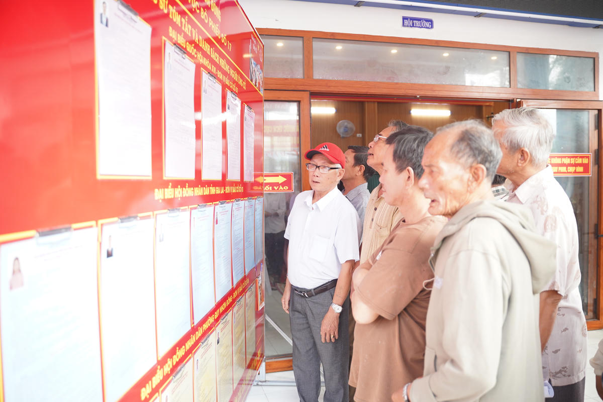 Cử tri&nbsp;phường Quy Nhơn Đông đang xem niêm yết danh sách ứng cử viên. Ảnh: Đình Sang.
