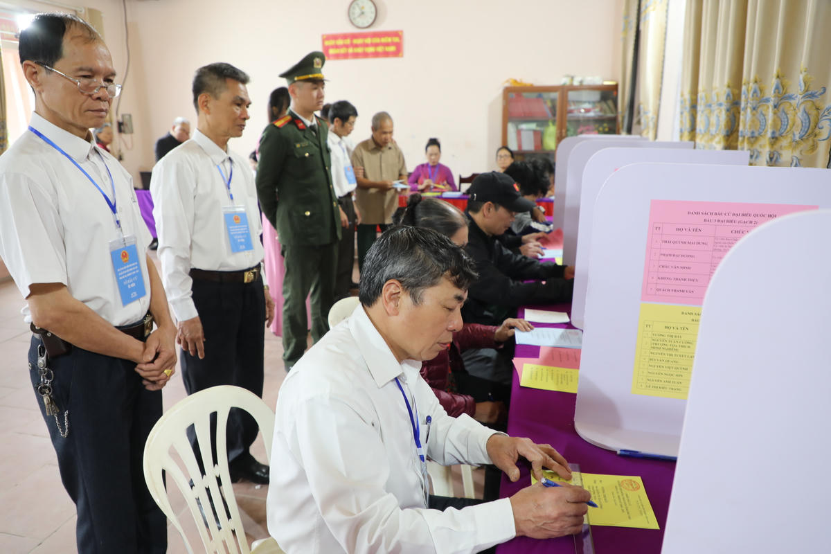 Cử tri thôn Cổ Tích thực hiện quyền và trách nhiệm bầu cử với sự hỗ trợ của thành viên tổ bầu cử. Ảnh: Tùng Duy