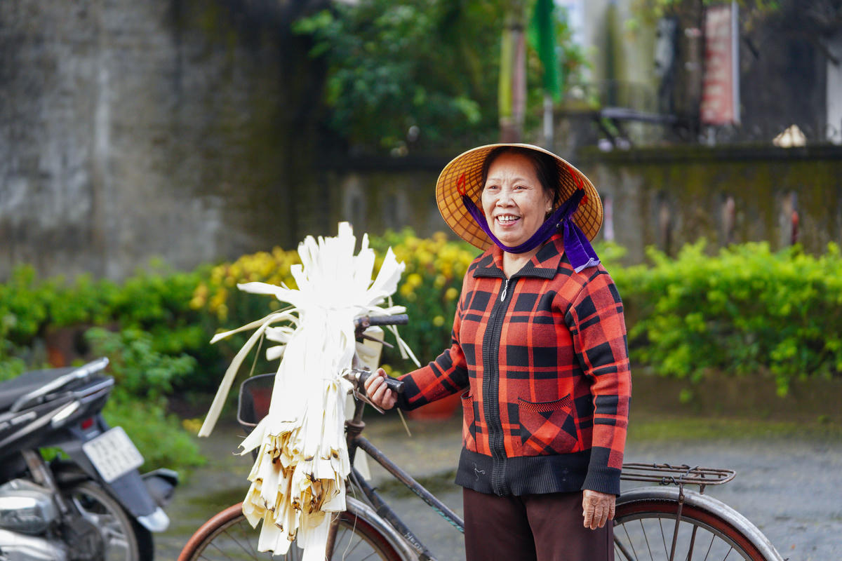 Bà Nguyễn Thị Thắm tạm gác lại những vành nón còn dang dở để chỉnh trang trang phục, cùng nhau đến khu vực bỏ phiếu. Ảnh: Cẩm Kỳ&nbsp;
