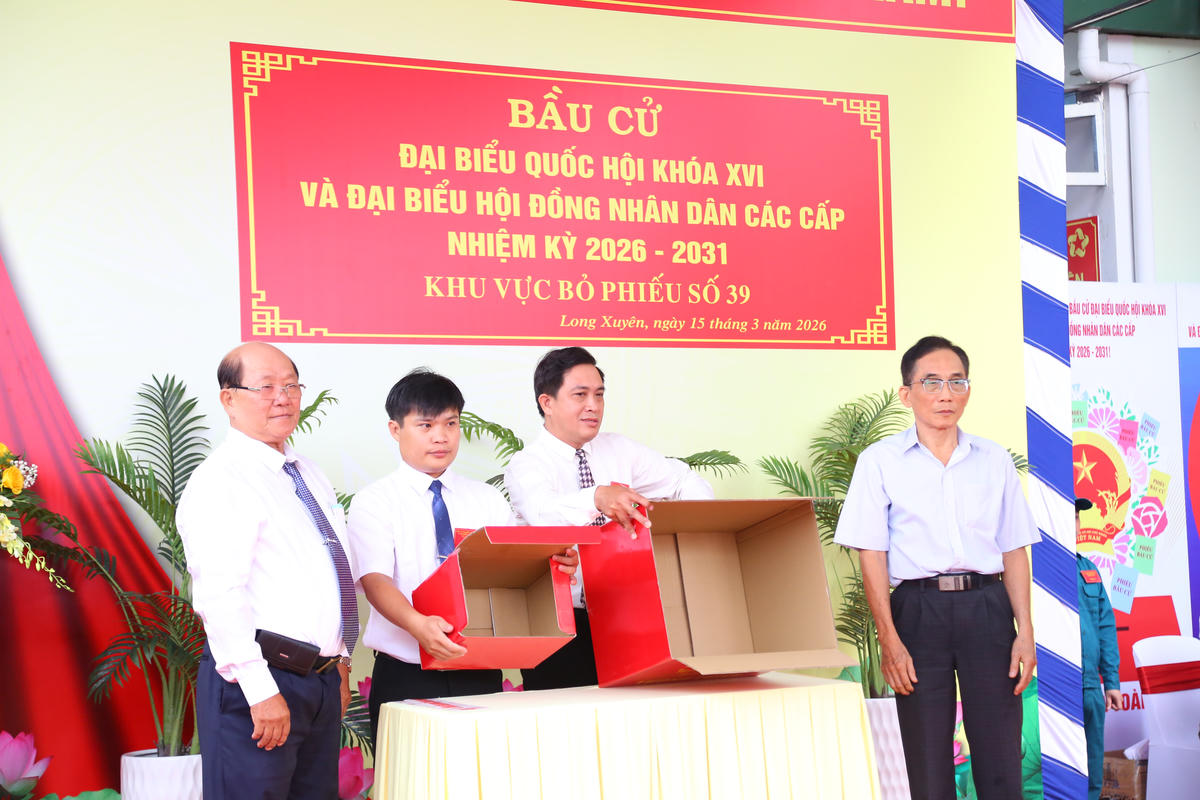 Thành viên Tổ bầu cử và cử tri kiểm tra thùng phiếu. Ảnh: Thanh Tiến