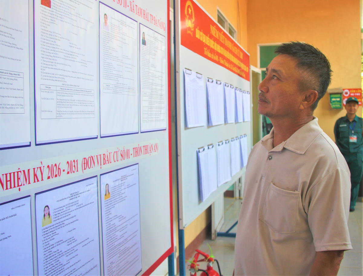 Ngư dân Huỳnh Hữu Thạnh đang xem niêm yết danh sách ứng cử viên. Ảnh: Chí Đại.