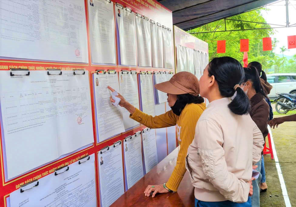 Cử tri xã Sơn Cẩm Hà đang xem niêm yết danh sách ứng cử viên. Ảnh: CV.