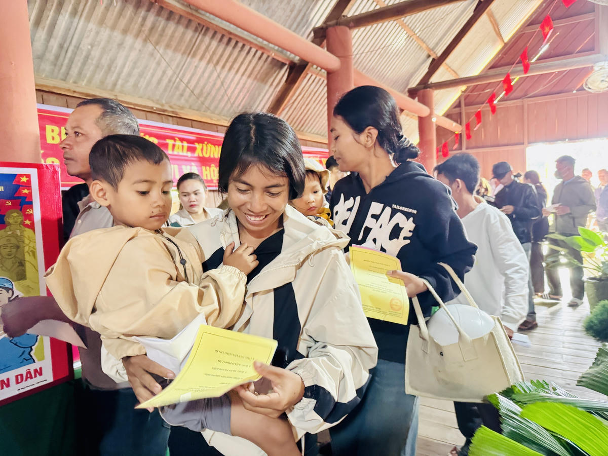 Nhiều bạn trẻ ở vùng biên bồng con trên tay cầm lá phiếu, háo hức lần đầu tiên được đi bầu cử. Ảnh: Thanh Nga.