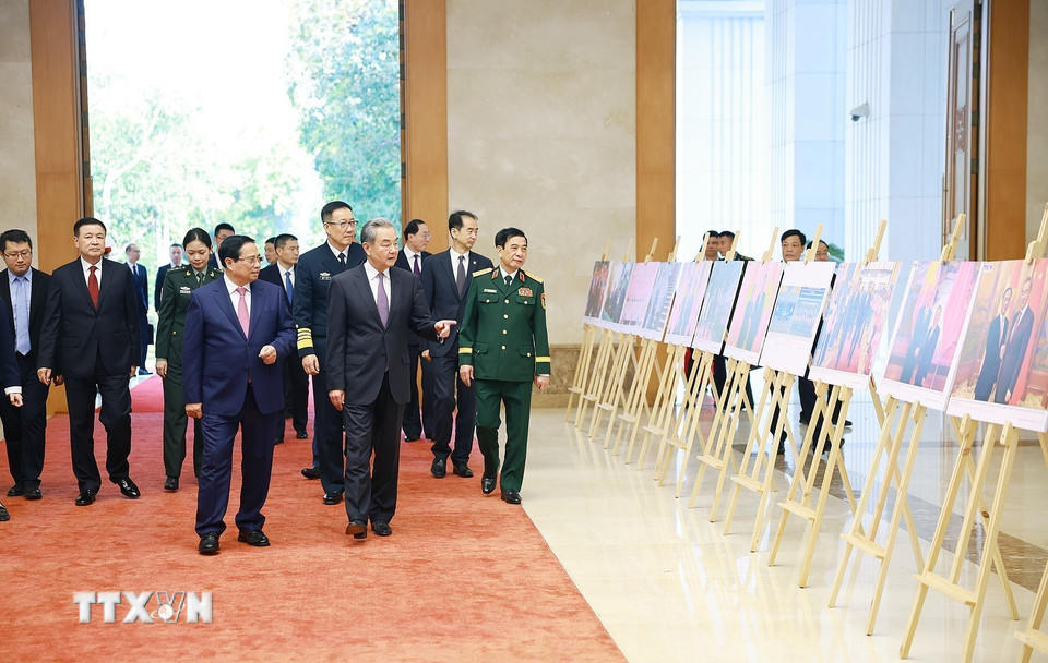 Thủ tướng Phạm Minh Chính và Bộ trưởng Ngoại giao, Quốc phòng, Công an Trung Quốc tham quan trưng bày ảnh về quan hệ hợp tác giữa hai nước Việt Nam-Trung Quốc do Thông tấn xã Việt Nam thực hiện. (Ảnh: Dương Giang/TTXVN)