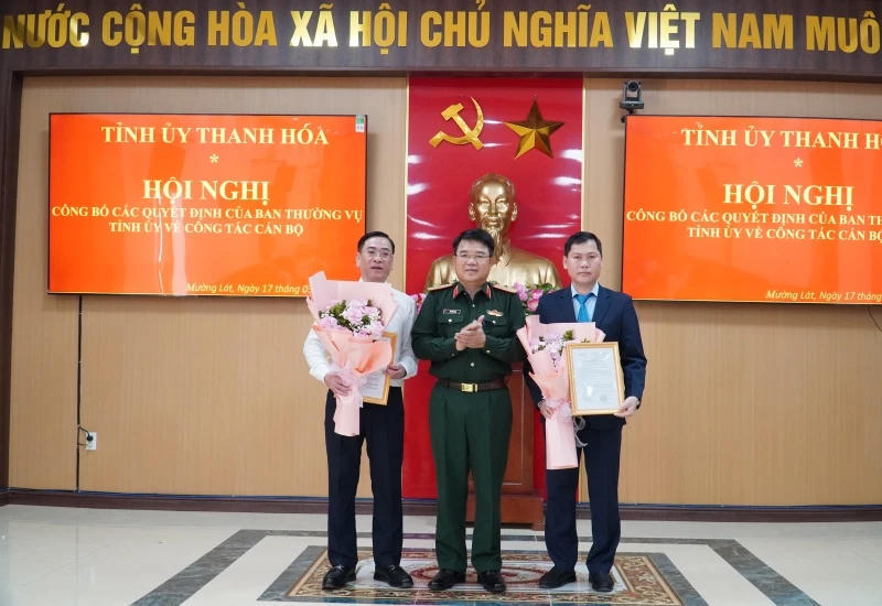 Thiếu tướng Vũ Văn Tùng - Chỉ huy trưởng Bộ CHQS tỉnh Thanh Hóa trao quyết định và tặng hoa cho ông Trịnh Văn Thế và ông Lê Ngọc Minh. Ảnh: Hoàng Lan.