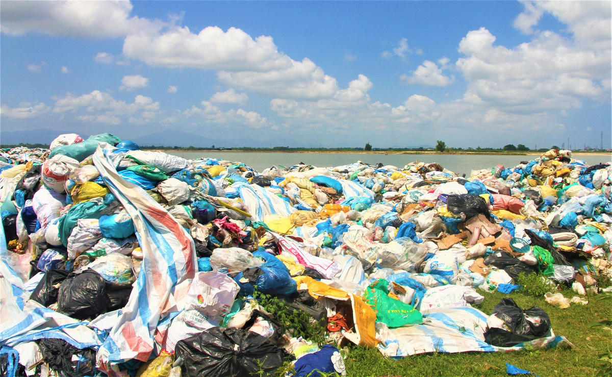 Rác thải chất thành đống lớn nằm ngổn ngang bên dòng sông Thu Bồn. Ảnh: Chí Đại.