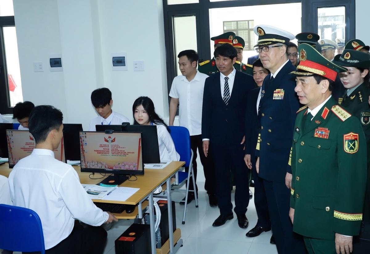 Hai Bộ trưởng cùng các đại biểu tham quan phòng máy vi tính và trò chuyện cùng các học sinh.