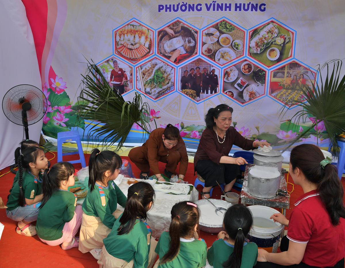 Các em nhỏ trải nghiệm, thưởng thức món ăn bánh cuốn Thanh Trì tại hội thi.