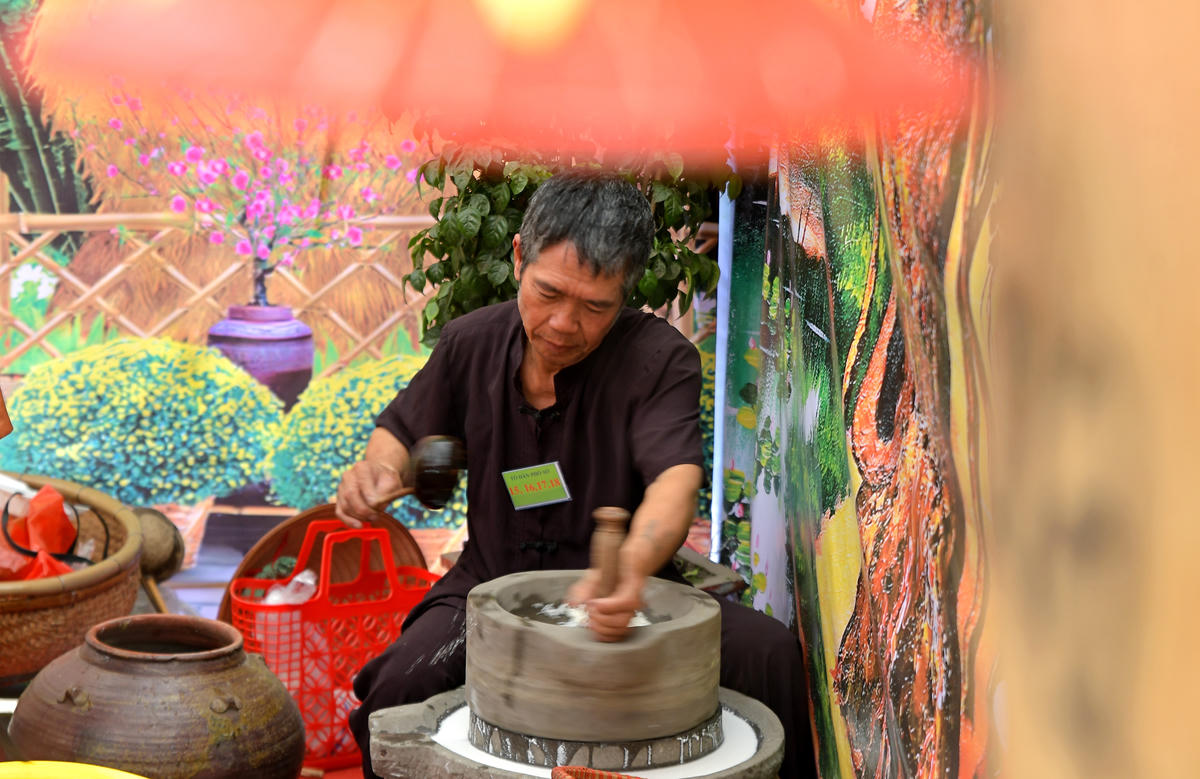 Nghệ nhân say bột bằng cối đá truyền thống.