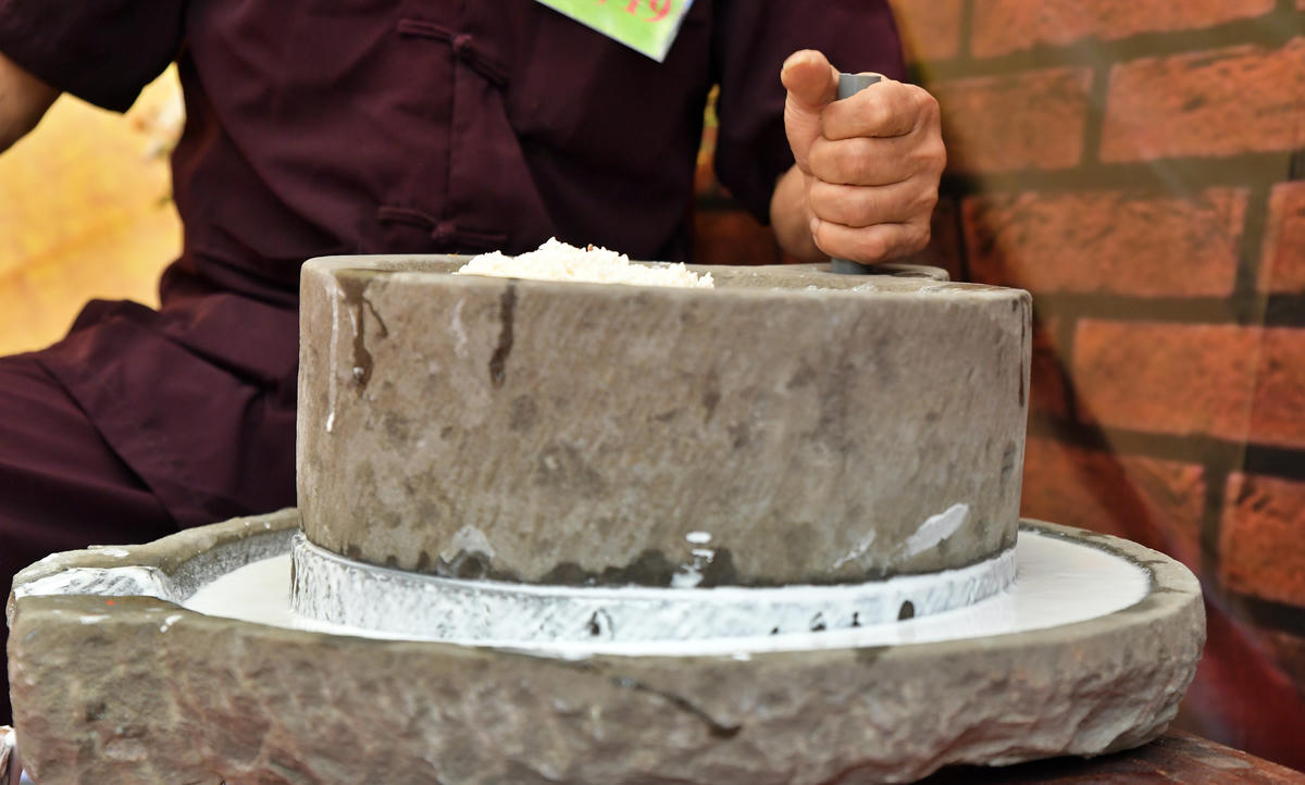 Những dòng bột trắng mịn chảy ra từ cối đá.