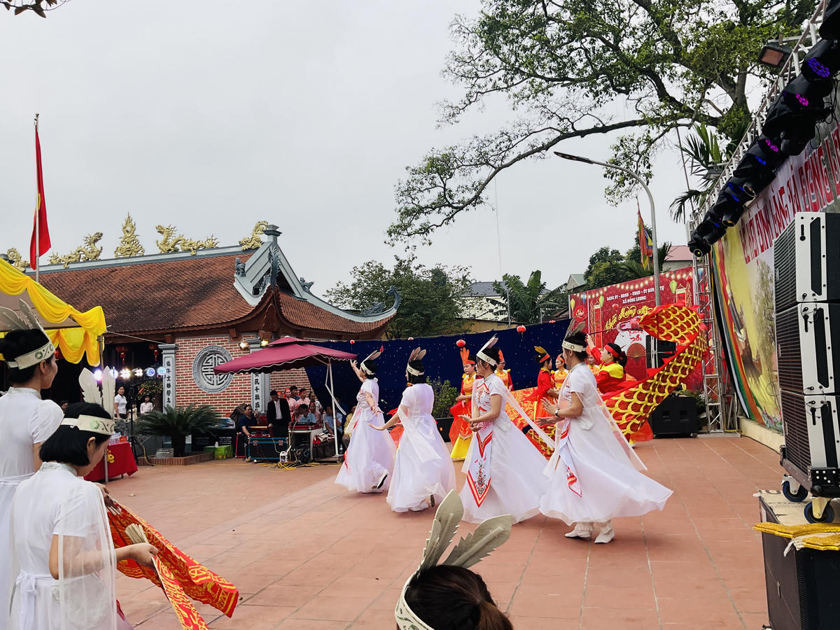 Biểu diễn văn nghệ hội làng bên tán đa di sản và ngôi Đình Cả ngày 19/3. Ảnh: Tùng Duy.