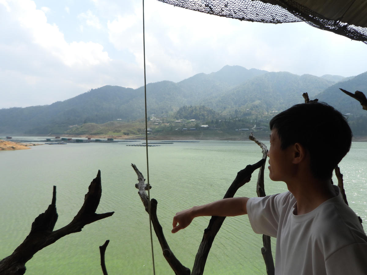 Anh Giàng A Quả ngao ngán nhìn về phía lòng hồ bị ô nhiễm và chia sẻ gia đình anh cũng lao đao vì tình trạng trên.