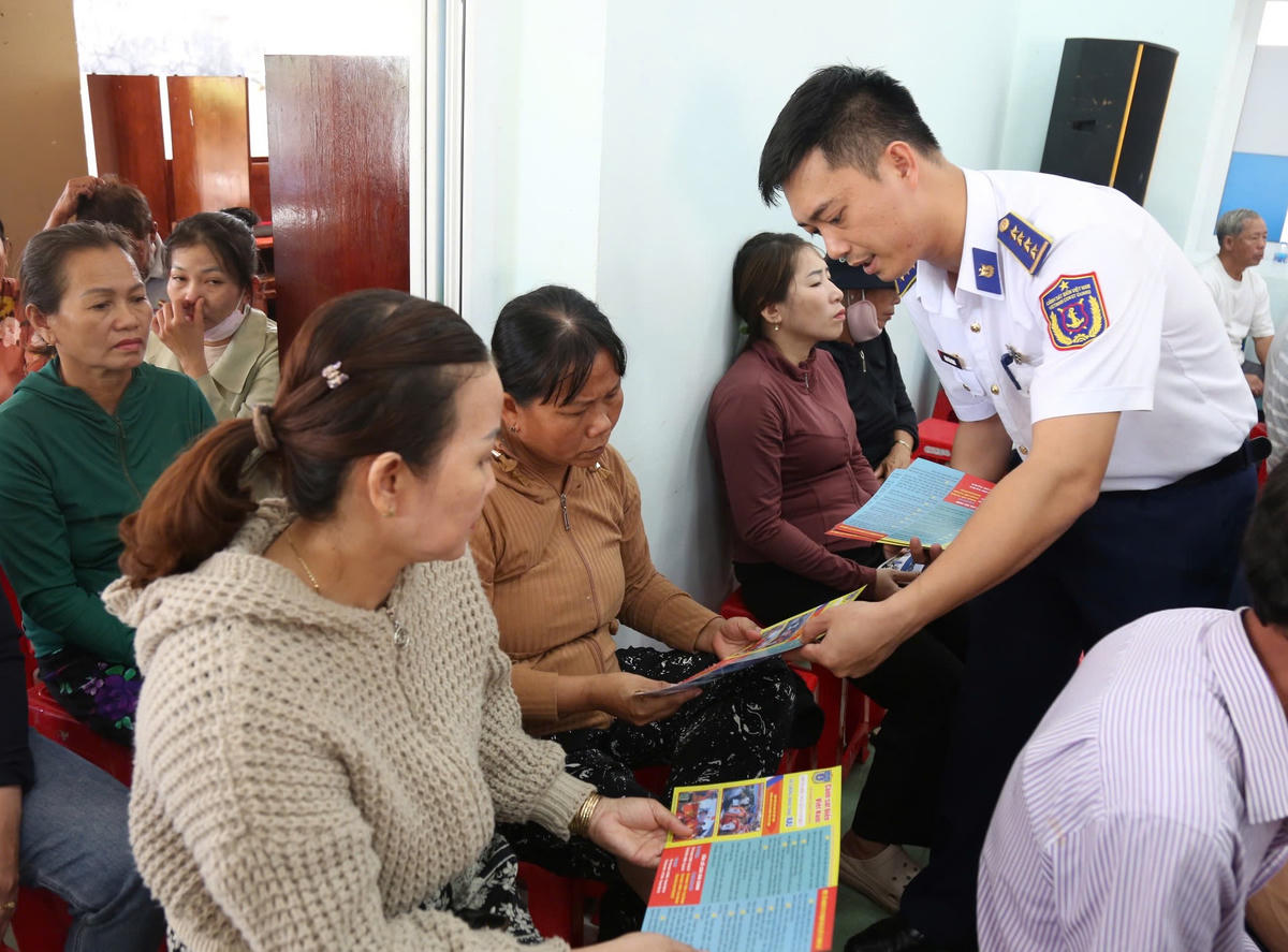 Phát tờ rơi tuyên truyền cho ngư dân tại chương trình. Ảnh: Đức Định.