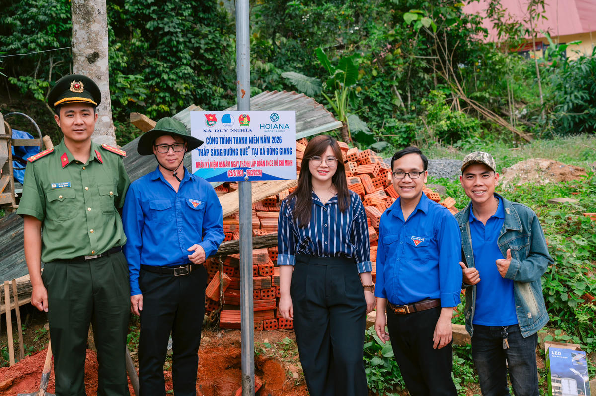 Các bạn đoàn viên bên những trụ đèn năng lượng mặt trời thắp sáng đường quê. Ảnh: Hương Tràm