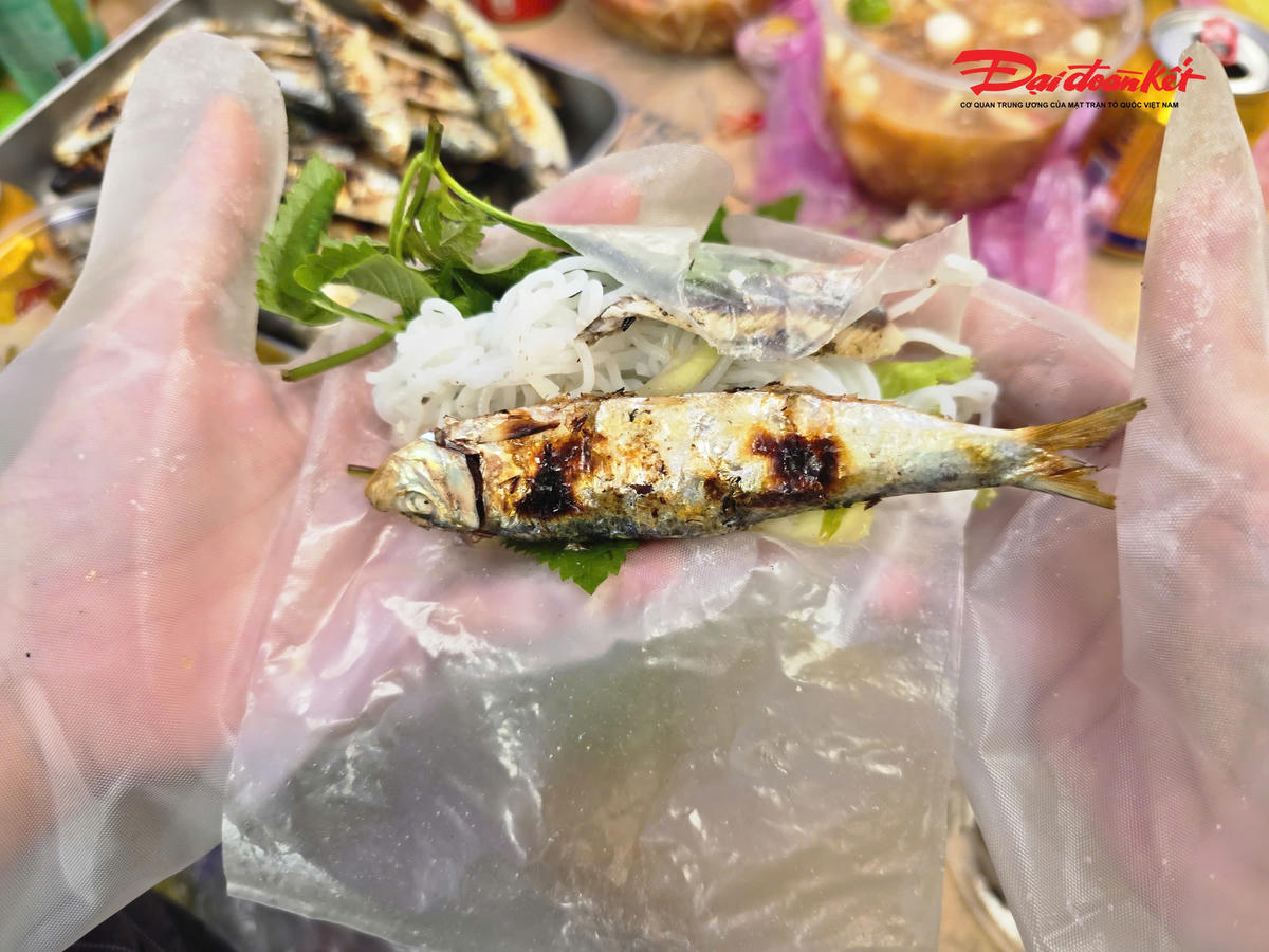 Cá trích nướng nóng hổi được cuốn cùng rau sống, bún, bánh tráng và chấm nước mắm ớt khiến du khách mê mẩn. Ảnh: ĐB