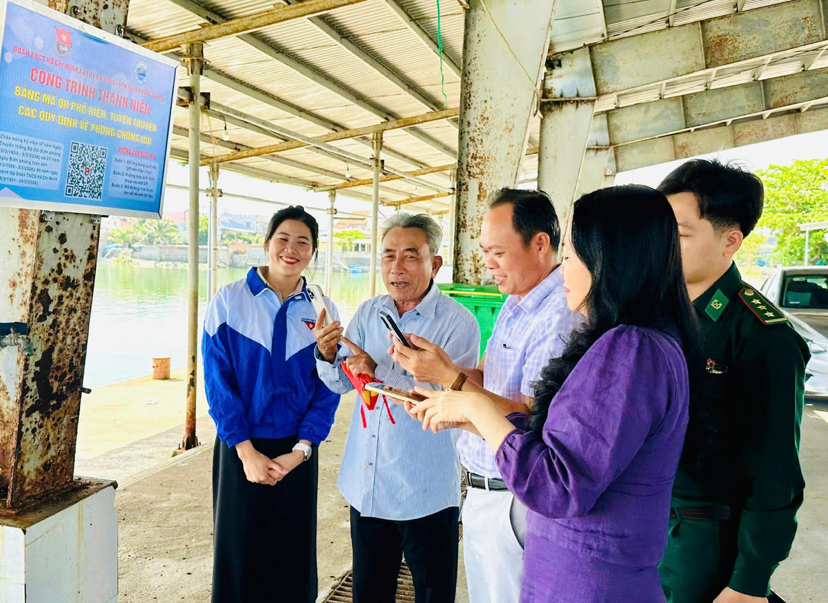 Ngư dân quét mã QR “Bảng mã QR phổ biến, tuyên truyền các quy định về phòng, chống IUU” tại cảng cá Tiên Châu. Ảnh: Thùy Dung.