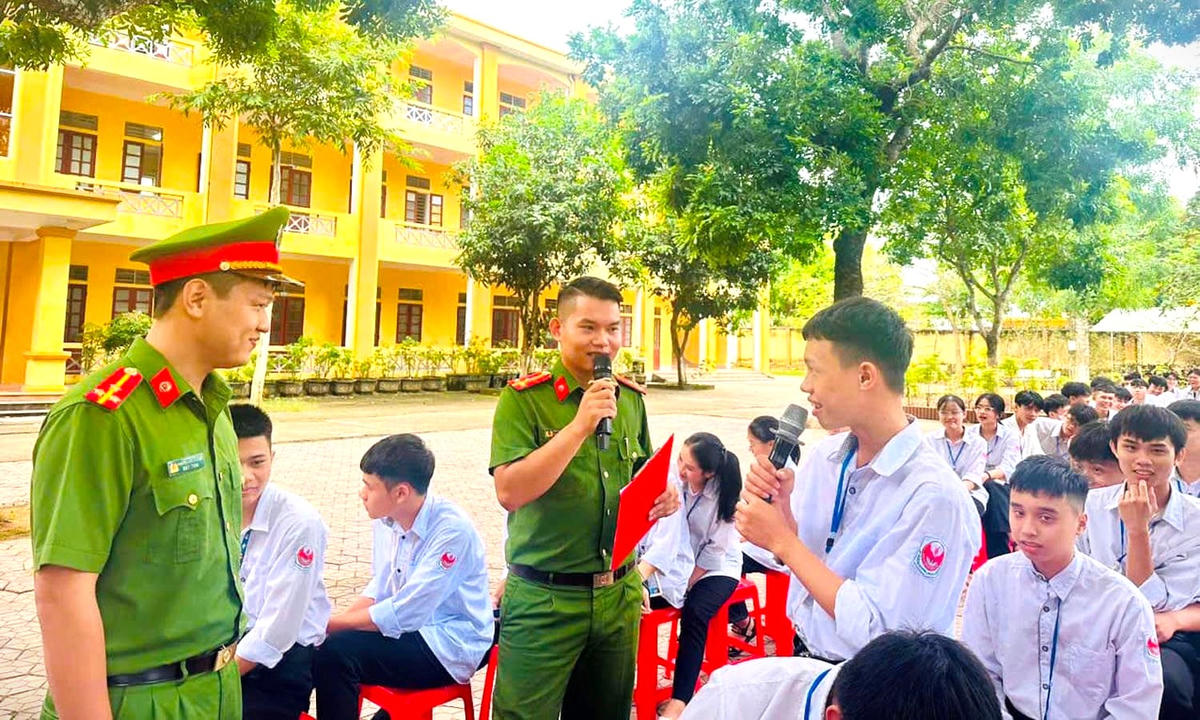 Lực lượng công an phối hợp với nhà trường tuyên truyền về pháp luật tham gia giao thông an toàn cho học sinh. Ảnh: G.B.