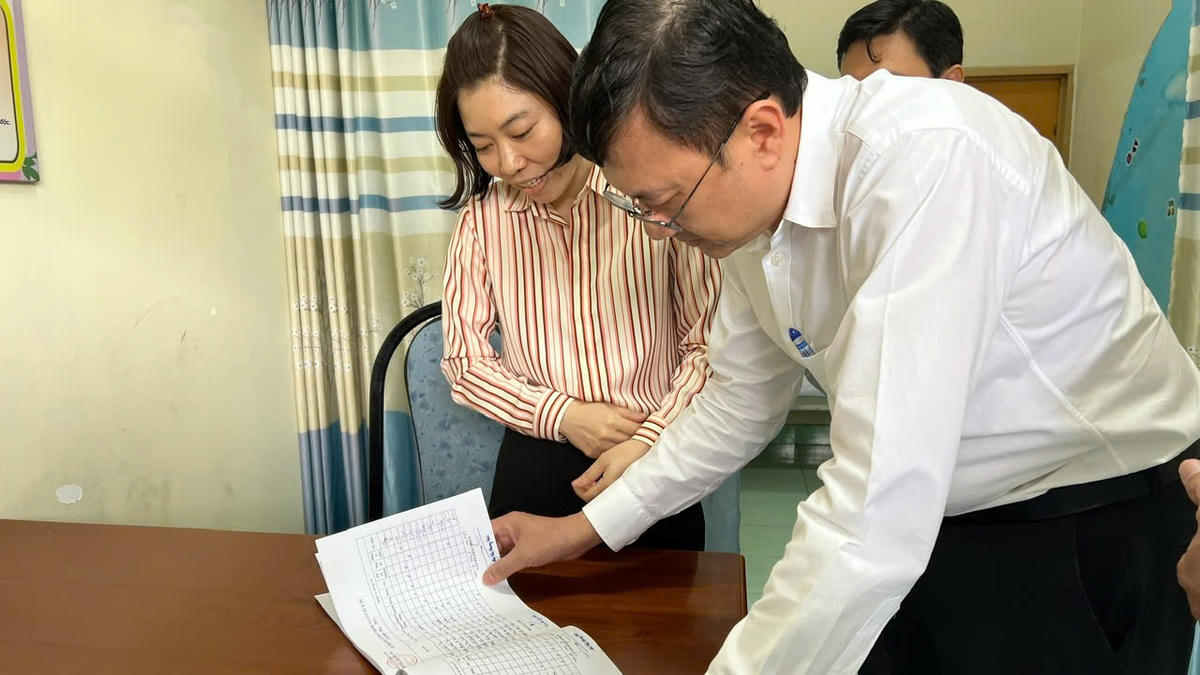 PGS.TS.BS. Nguyễn Vũ Thượng - Phó Viện trưởng Viện Pasteur TP Hồ Chí Minh, đang kiểm tra Sổ theo dõi trẻ nghỉ học vì bệnh của trường mầm non tại Đồng Nai. Ảnh: Viện&nbsp;Viện Pasteur TP Hồ Chí Minh