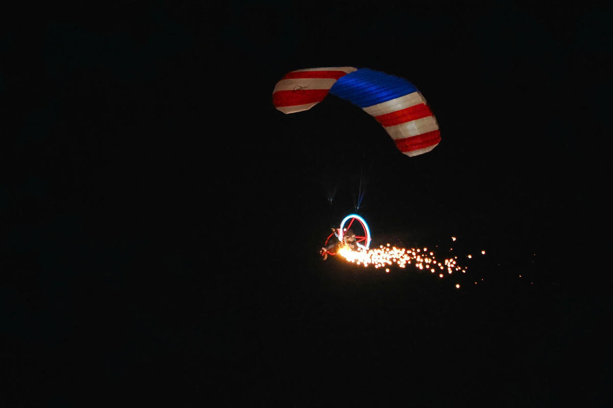 Các vận động viên dù lượn có động cơ bay diễu hành kết hợp bắn pháo hoa trên bầu trời sông Bạch Đằng. Ảnh: Hoàng Hùng.