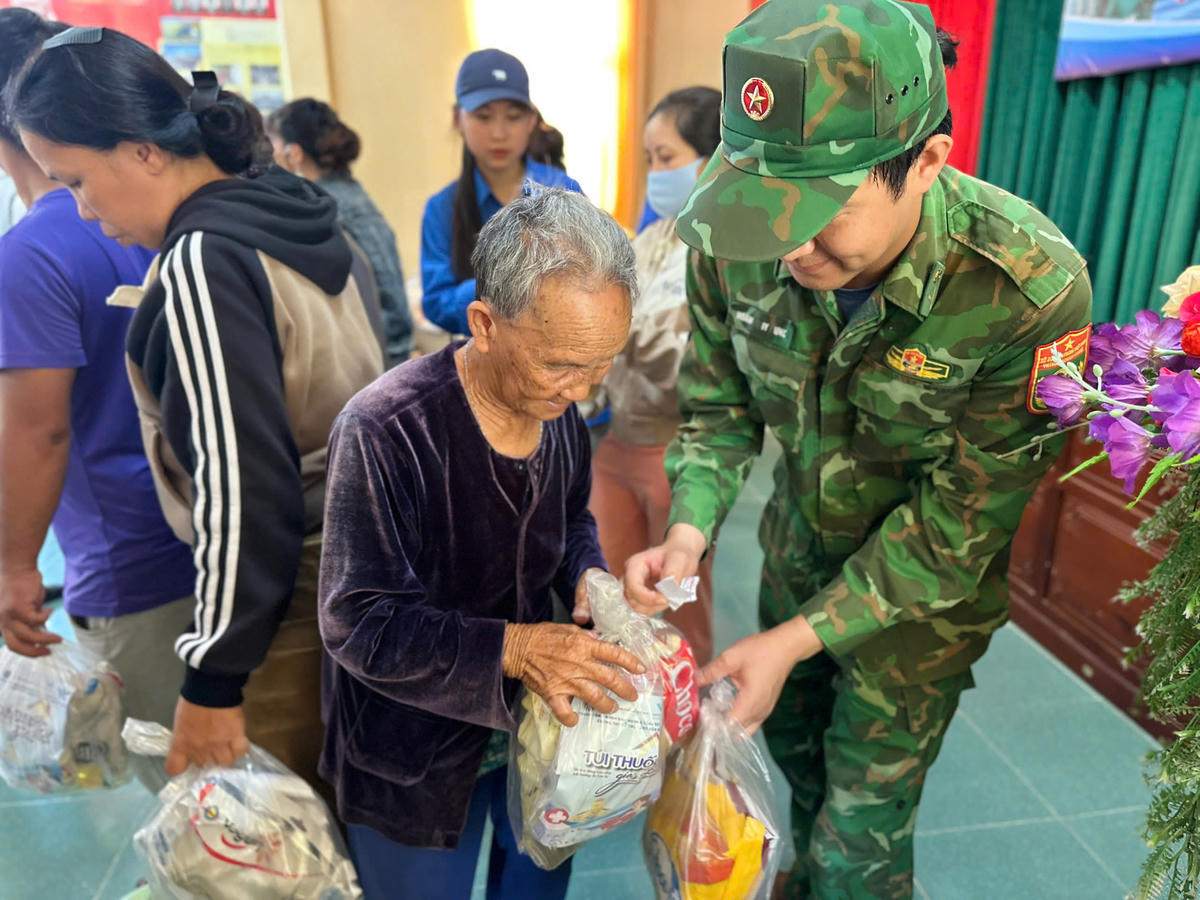 Cán bộ Biên phòng trao tận tay các phần quà hỗ trợ cho người dân khó khăn tại xã Ô Loan. Ảnh: Thùy Dung.