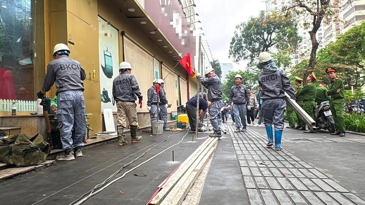 Các lực lượng chức năng tổ chức rào tôn tại tầng 1 nhà 51 Huỳnh Thúc Kháng ngày 27/3. Ảnh T.L