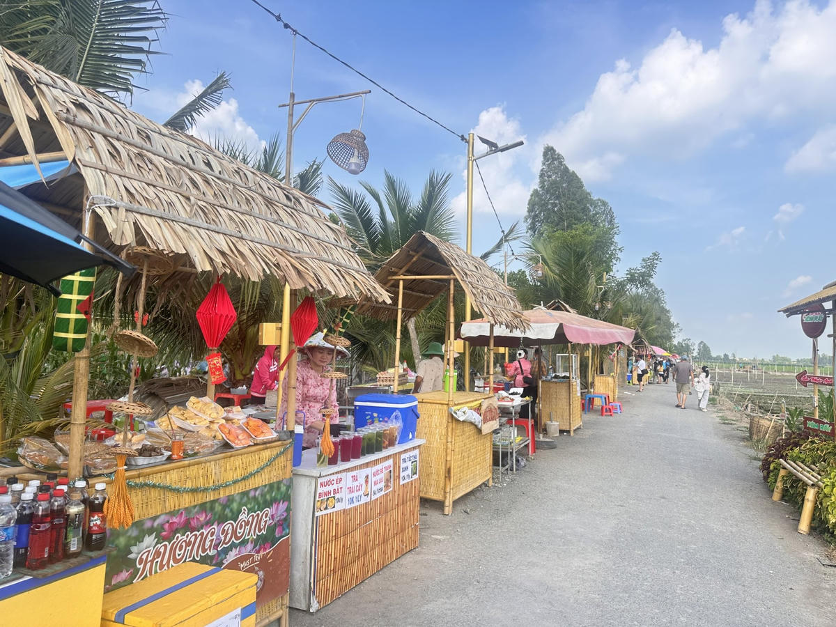 Chợ phiên Xóm Rẫy quy tụ gần 30 quầy hàng với bánh dân gian, nước uống truyền thống, nông sản sạch và không gian sinh hoạt đờn ca tài tử đậm chất miền Tây. (Ảnh: Trung Ngãi).