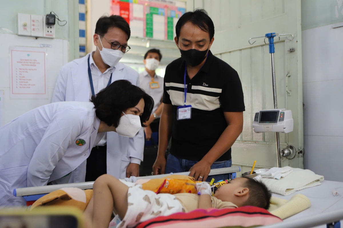 Thứ trưởng Bộ Y tế Nguyễn Thị Liên Hương hỏi thăm sức khỏe bệnh nhi mắc bệnh tay chân miệng điều trị tại Bệnh viện Nhi đồng 2 (TP.HCM). Ảnh: TL.