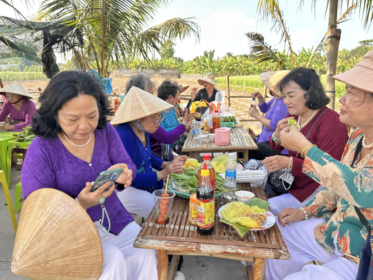 Người dân và du khách thưởng thức ẩm thực dân dã tại chợ quê Xóm, mô hình du lịch cộng đồng góp phần nâng cao thu nhập cho nông dân. (Ảnh: Trung Ngãi).