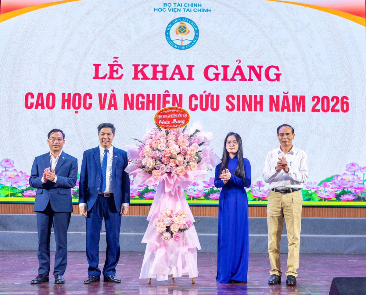 Tân nghiên cứu sinh Nguyễn Thị Thu Thủy đại diện các tân học viên cao học và tân nghiên cứu sinh tặng hoa lãnh đạo Học viện. Ảnh: Văn Hoa