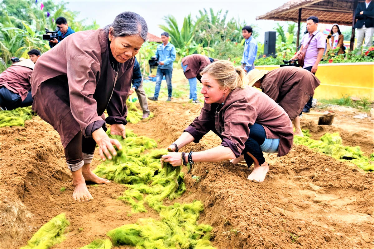 Du khách nước ngoài trải nghiệm trồng rau ở Trà Quế. Ảnh: Chí Đại.