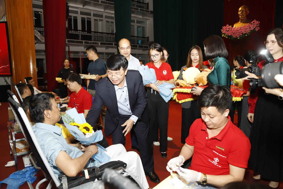 Ban Tổ chức tặng hoa những người tham gia hiến máu tình nguyện. Ảnh: Minh Lý.