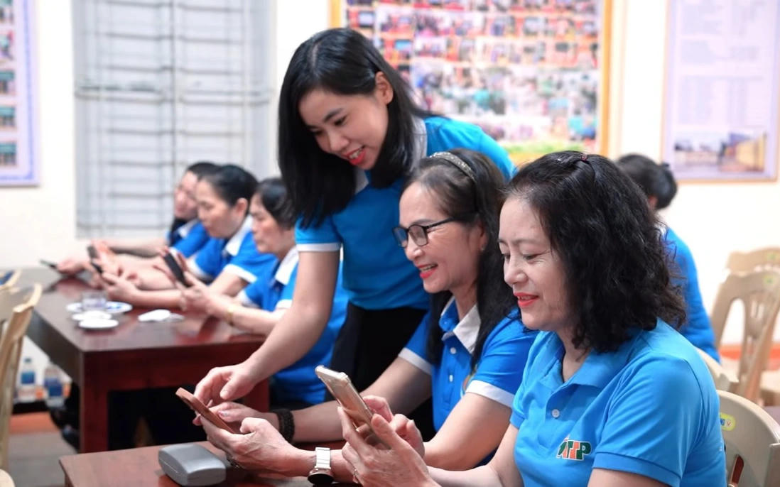 Cán bộ Hội Liên hiệp Phụ nữ phường Bỉm Sơn (tỉnh Thanh Hóa) hướng dẫn hội viên sử dụng các ứng dụng trên điện thoại thông minh. Ảnh: An Nhi.