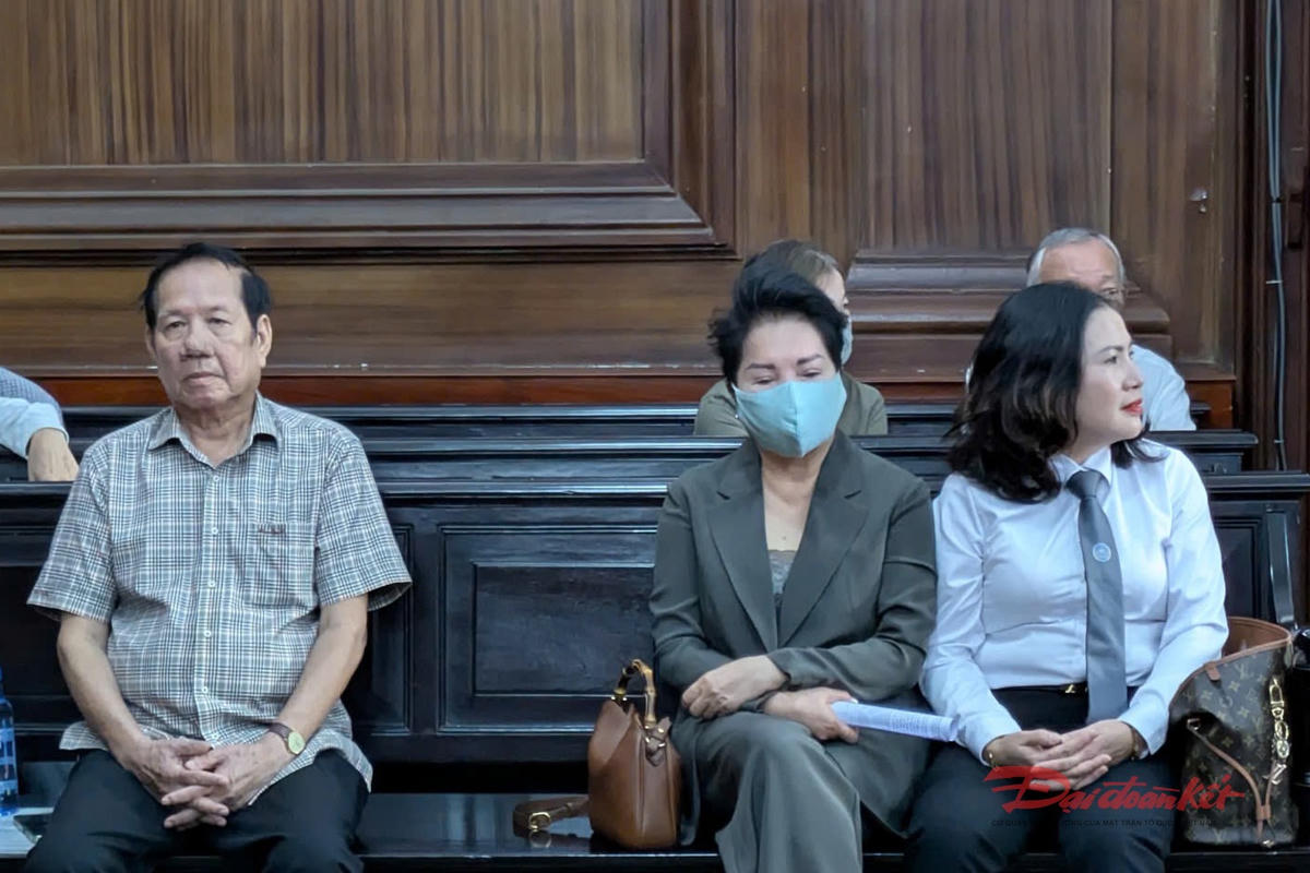 Luật sư (bên phải) tranh thủ thời gian đầu phiên tòa gặp gỡ bị cáo trong vụ án. Ảnh: TL.