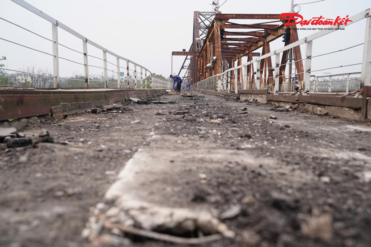 Tại một số nhịp cầu Long Biên, những tấm đan bê tông mặt đường đã xuống cấp được cào bóc hoàn toàn, để lộ phần kết cấu bên dưới.
