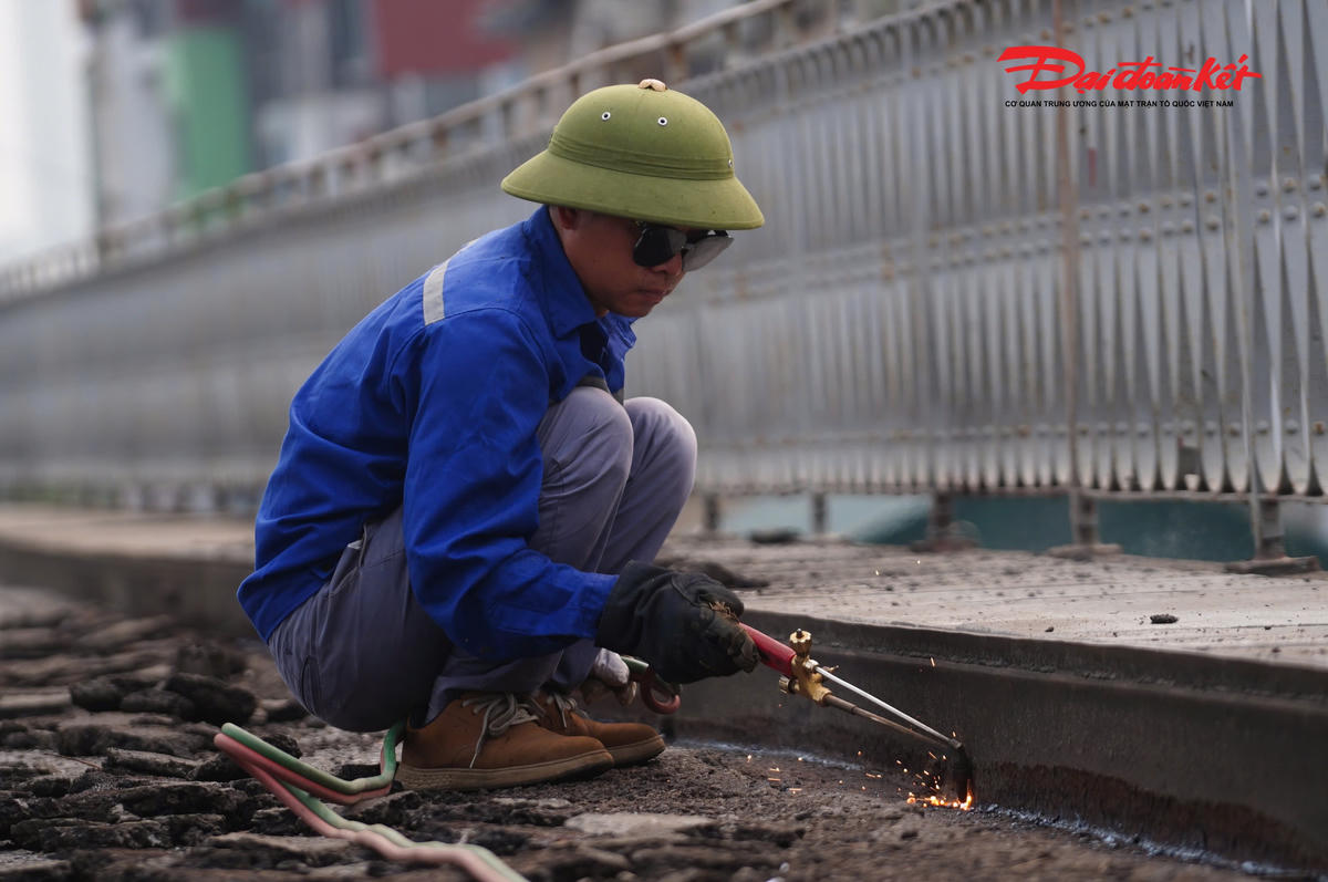 Các công nhân tỉ mỉ xử lý từng chi tiết, dọn dẹp lớp vật liệu hư hỏng, chuẩn bị cho việc thay thế, gia cố, nhằm đảm bảo độ bền và an toàn cho mặt cầu sau khi hoàn thiện.
