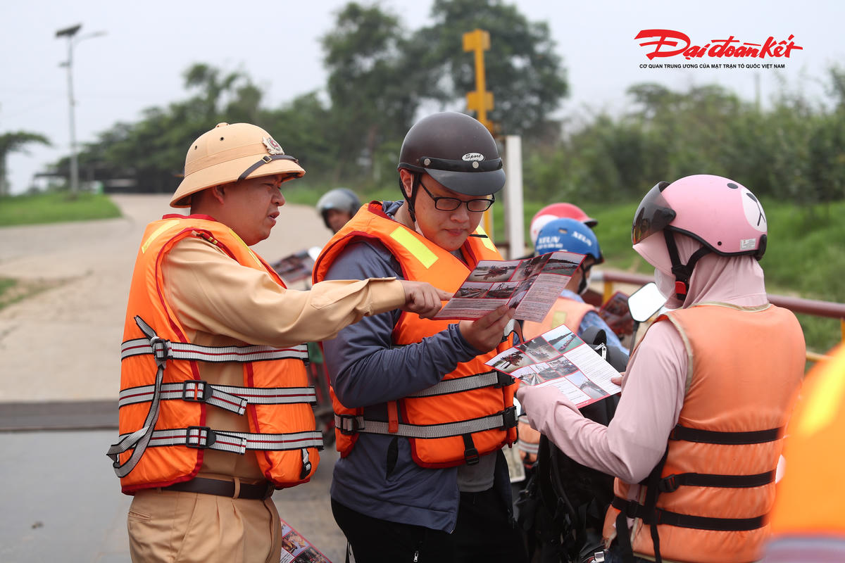 Lực lượng Cảnh sát đường thủy phát tờ rơi, tuyên truyền, nhắc nhở người dân chấp hành quy định an toàn khi đi phà trên sông Hồng.