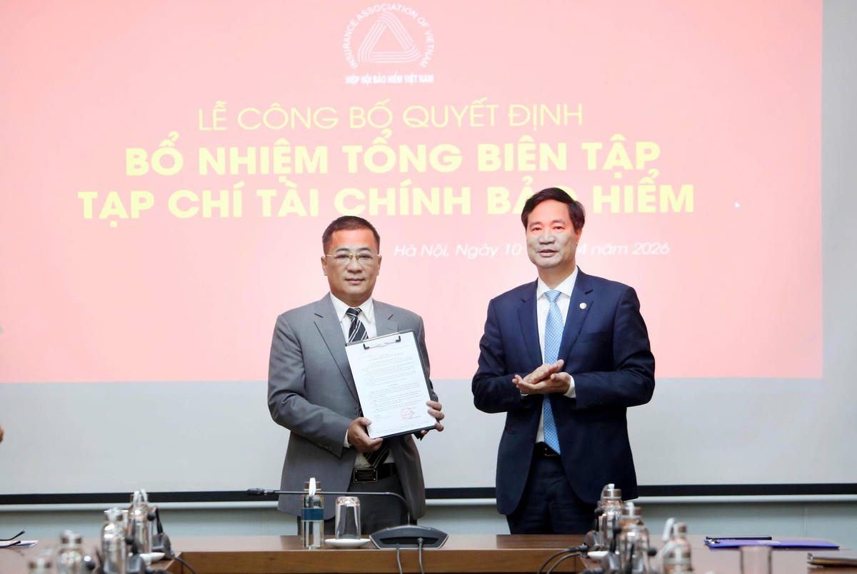 Ông Nguyễn Xuân Việt, Chủ tịch Hiệp hội Bảo hiểm Việt Nam trao quyết định bổ nhiệm cho nhà báo Nguyễn Phong Cầm. Ảnh: Tuấn Minh.