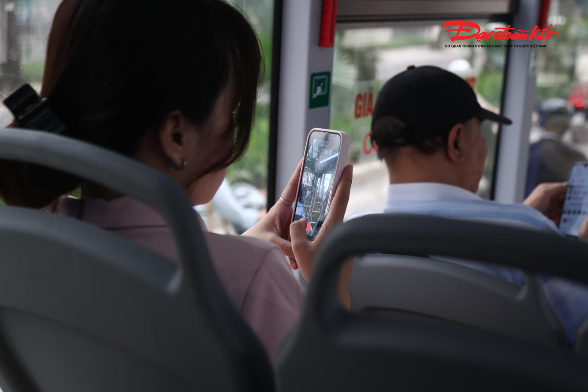 Nhiều hành khách thích thú ghi lại hình ảnh xe buýt điện sạch đẹp, hiện đại.