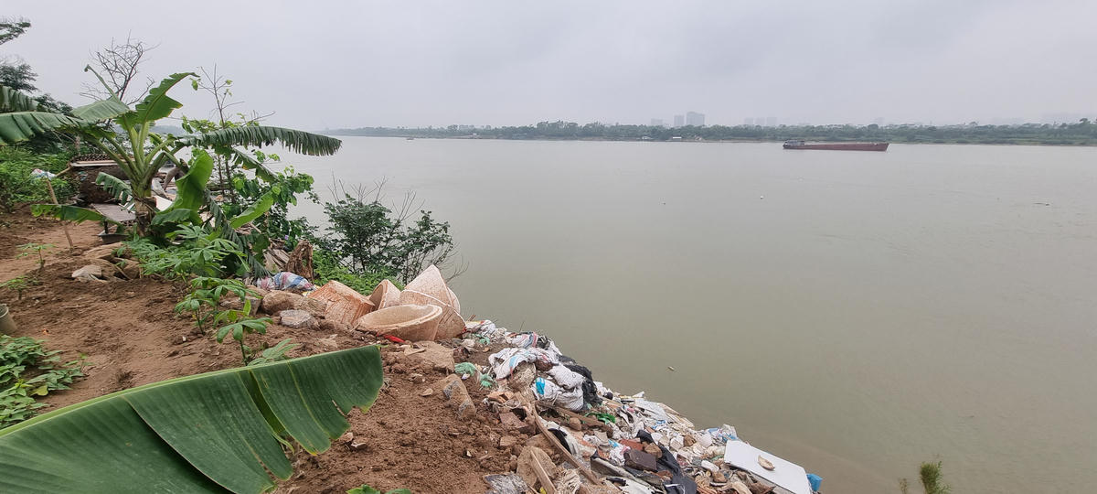 Tình trạng đổ chất thải rắn làm thay đổi dòng chảy. Ảnh: Hà An.