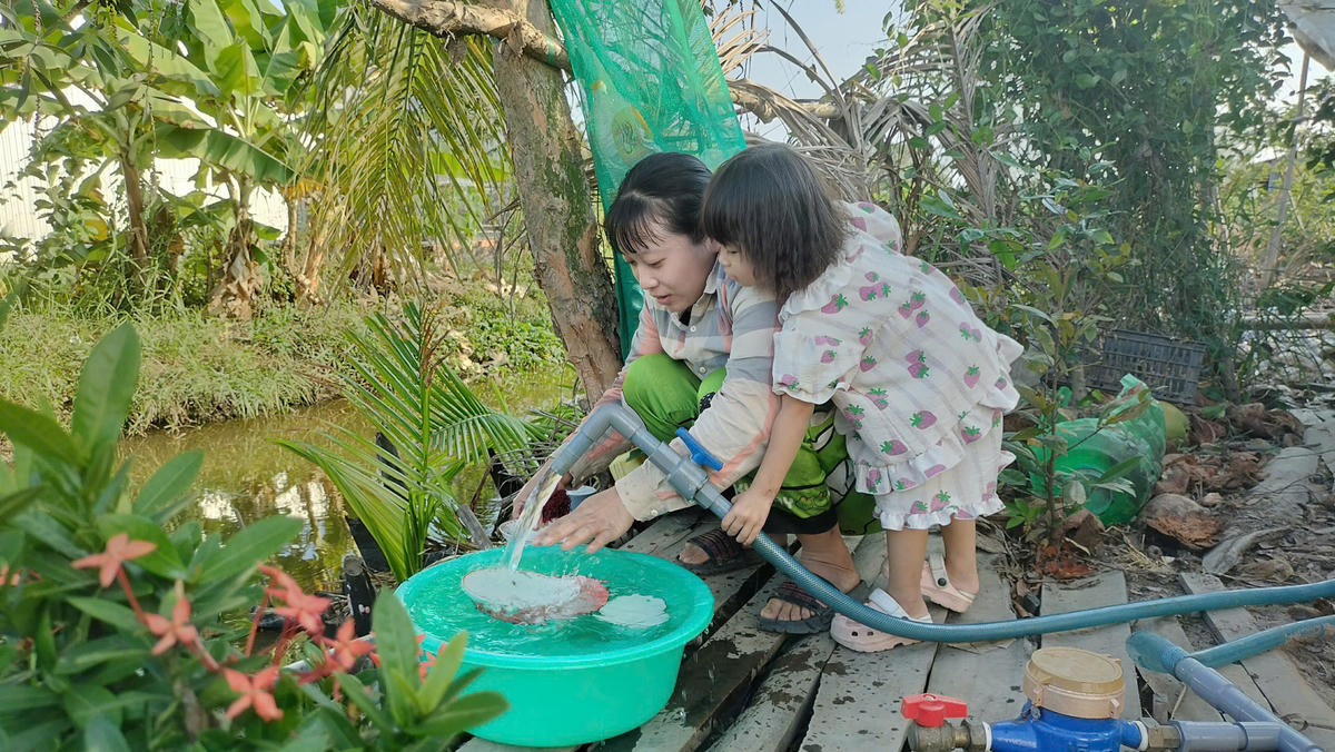 Sau nhiều năm chờ đợi, chị Trần Bích Thanh (ngụ ấp Thanh Tùng, xã Biển Bạch được sử dụng nước sạch trong niềm vui. Ảnh: Nguyên Du.