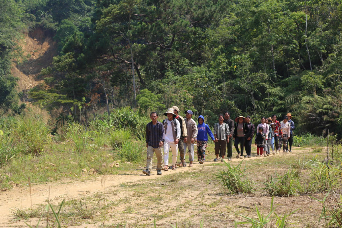 Người dân các bản giáp biên huyện Kà Lùm (Lào) đi bộ đến thôn A Tu 1, xã Hùng Sơn tham dự Tết Bunpimay. Ảnh: Nguyễn Tín.