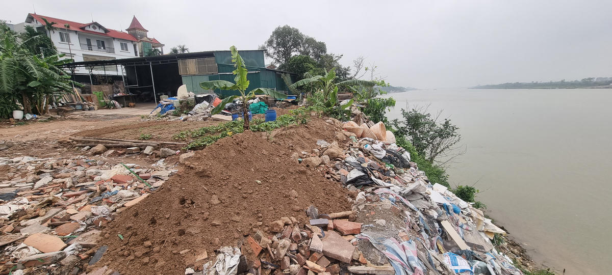 Khối lượng lớn chất thải rắn do người dân làng gốm đổ dọc sông Hồng. Ảnh: Hà An.