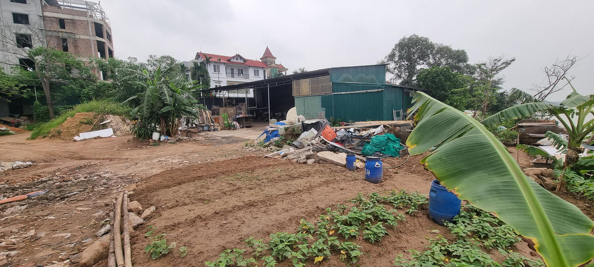 Nhà xưởng, cơ sở sản xuất mọc lên sau khi chất thải rắn được đổ xuống ngay sát mép bờ sông Hồng. Ảnh: Hà An.