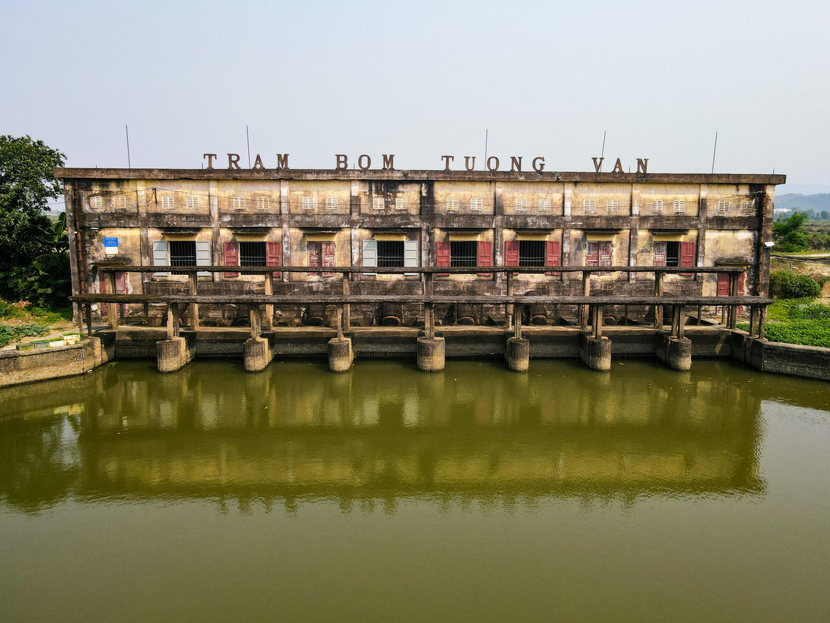 Bên ngoài trạm bơm, nhiều mảng tường loang lổ, bong tróc, lộ rõ lớp bê tông mục nát và cốt thép han gỉ. Hệ thống cửa, lan can, đường ống… đều trong tình trạng xuống cấp, nhiều vị trí có dấu hiệu hư hỏng nặng. Ảnh: Đình Minh