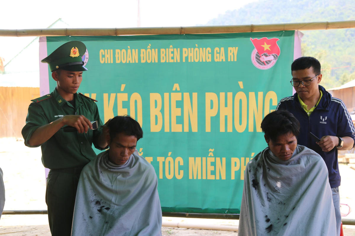 Bộ biên phòng” tận tình cắt tóc miễn phí cho người dân Lào sang giao lưu. Ảnh: Nguyễn Tín.