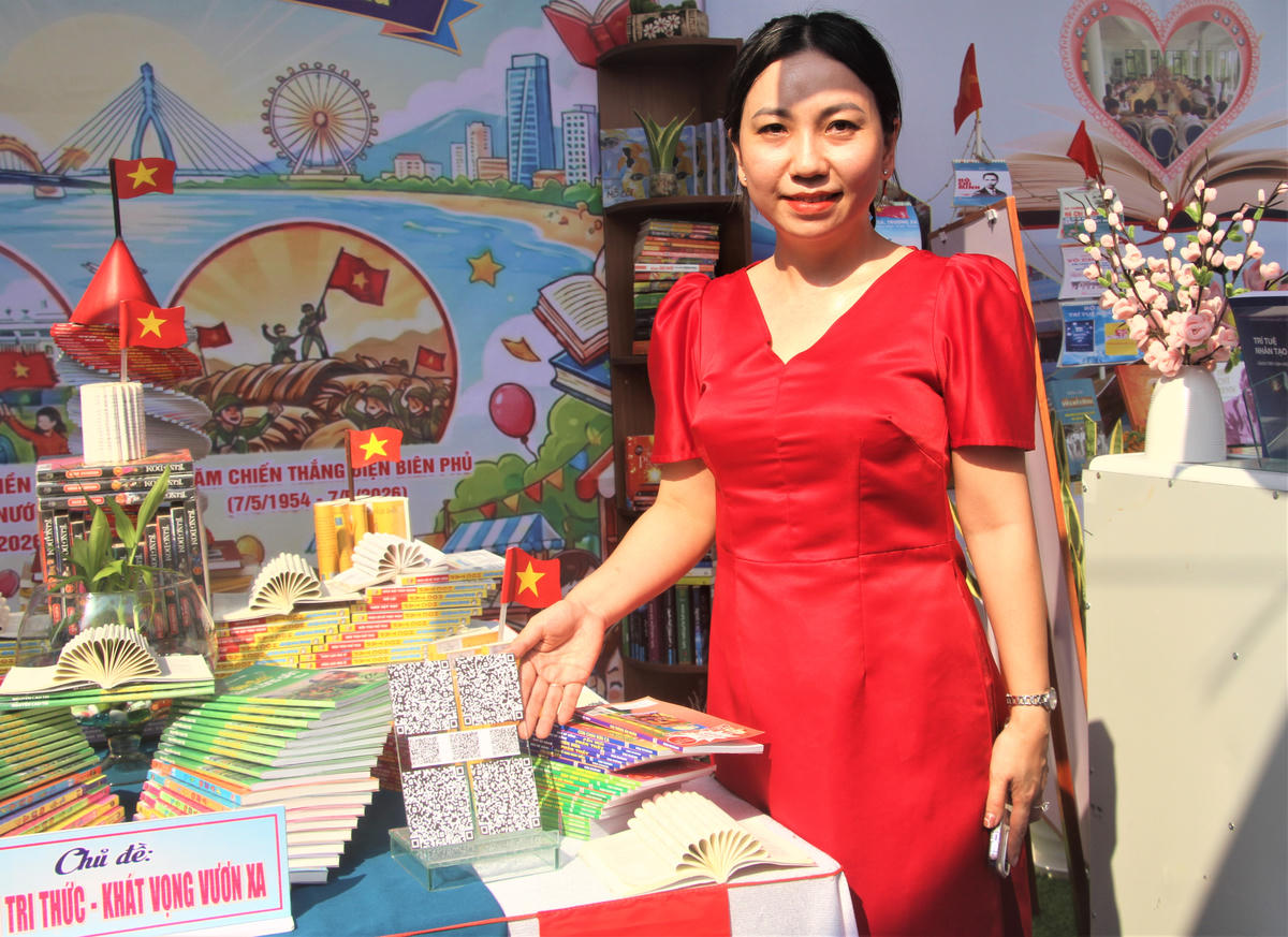 Cô giáo Ngô Thị Thanh Tuyền hướng dẫn người dân sử dụng mã QR để truy cập, xem các đầu sách. Ảnh: Chí Đại.